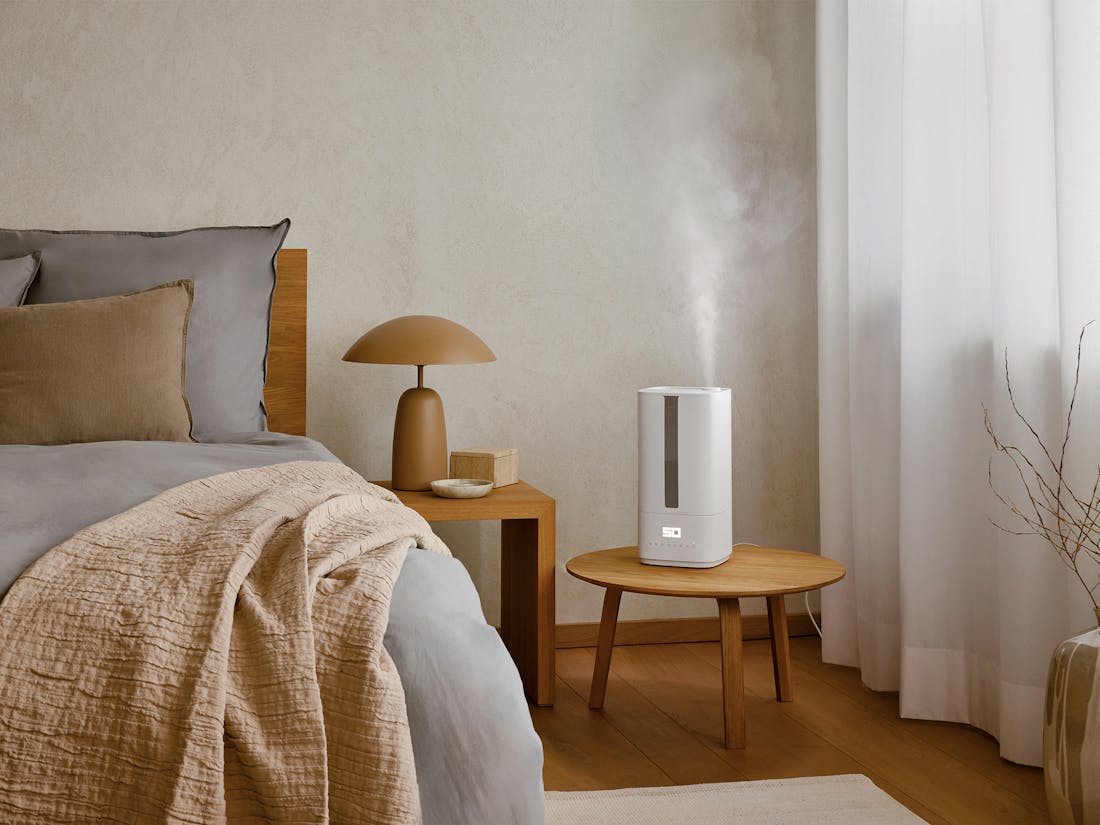 humidifier for bedroom placed on nightstand releasing mist